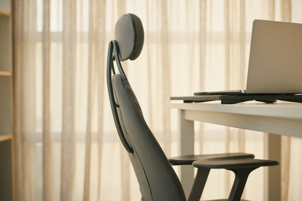 bureau minimaliste avec coussin ergonomique et support ordinateur portable en lumière douce