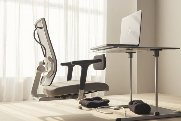 bureau minimaliste avec coussin ergonomique, support ordinateur portable et correcteur de posture