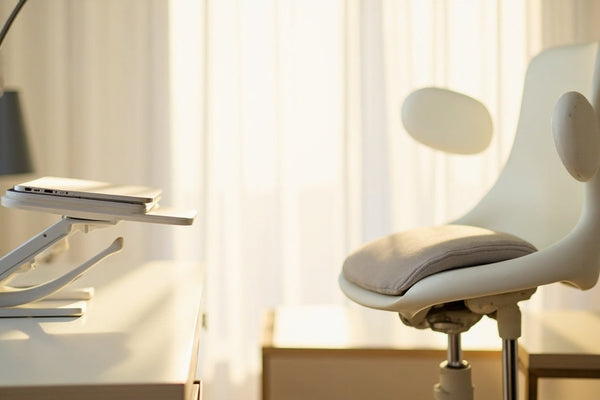 bureau minimaliste avec coussin ergonomique, support ordinateur portable et correcteur de posture