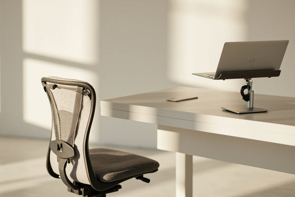 setup de télétravail minimaliste avec coussin ergonomique et support ordinateur portable