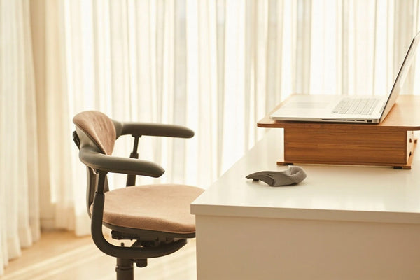 setup télétravail minimaliste avec coussin ergonomique et support ordinateur portable